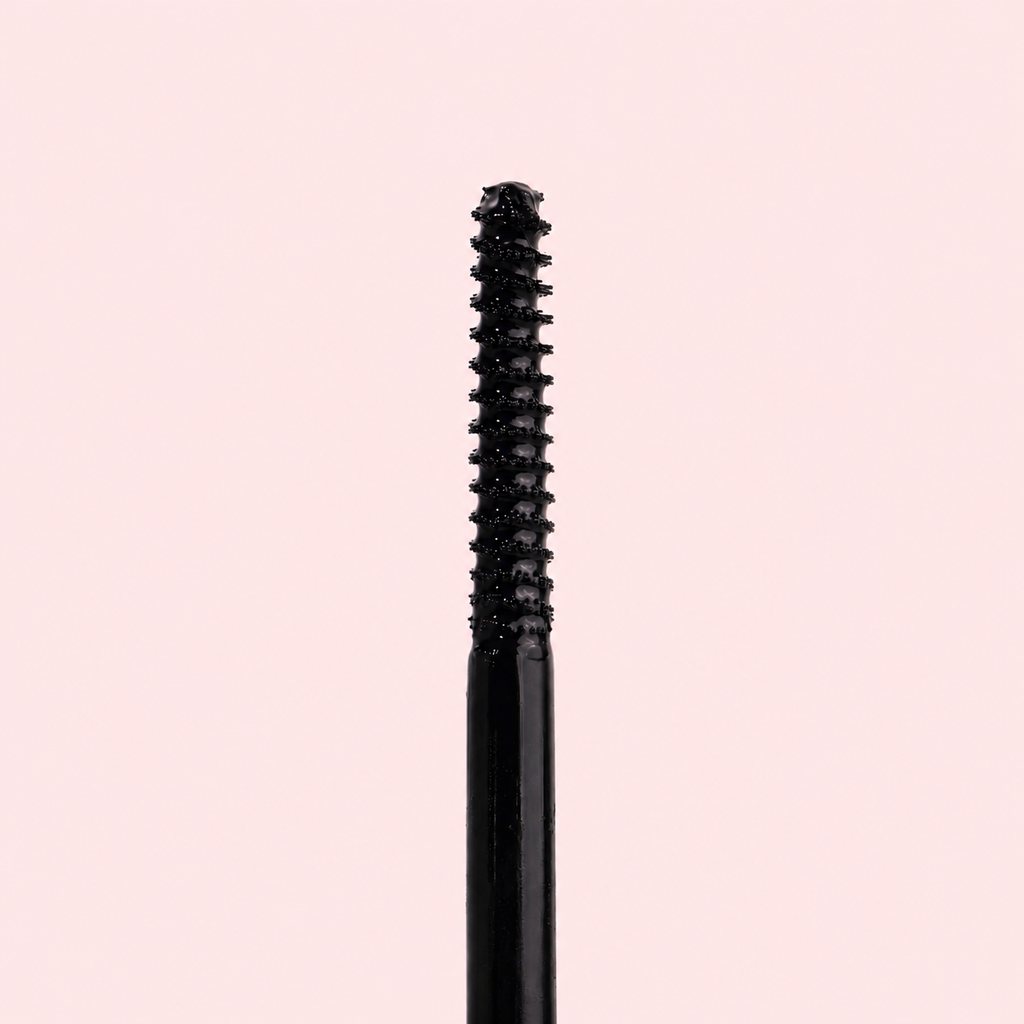Black eyelash curler on a pink background
