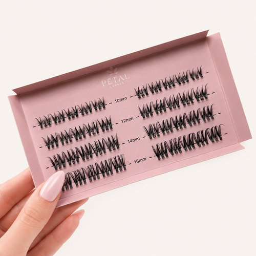 Set of false eyelashes in a pink case held by a hand with pink nail polish.