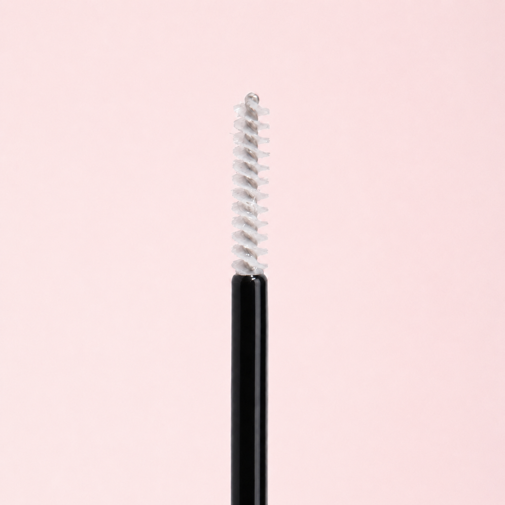 Black eyeliner pencil with silver cap on a light pink background