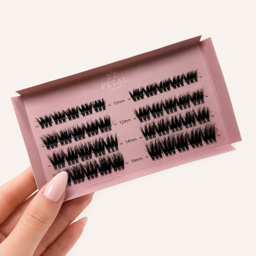 Set of false eyelashes in a pink case held by a hand on a white background