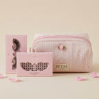Pink makeup bag with 'Petal' branded eyelash packaging on a beige background