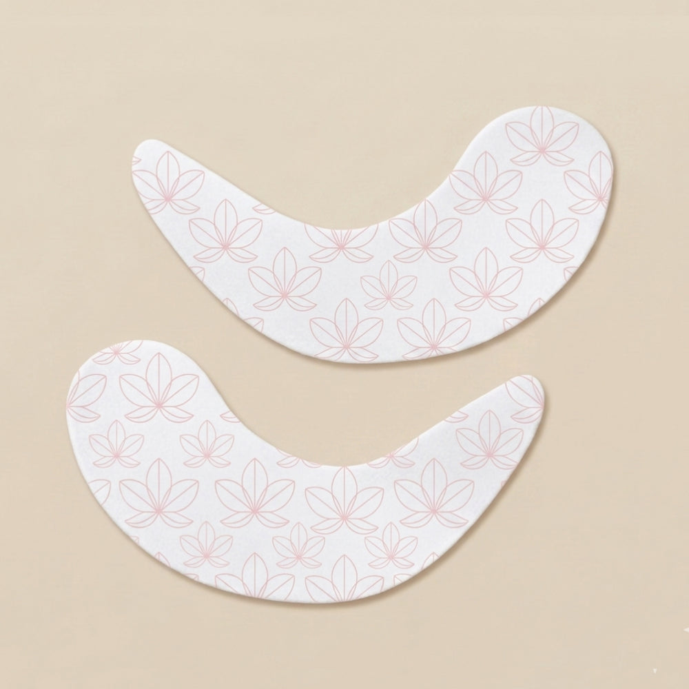 Two lotus patterned undereye patches on a creamy beige background.