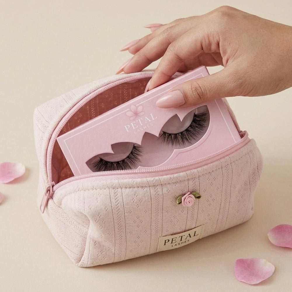 Pink makeup case with false eyelashes, held by a hand on a light background.